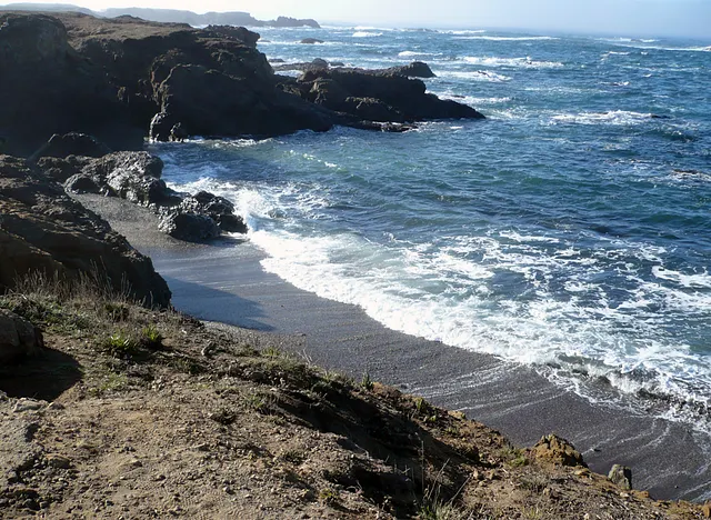 Glass Beach as seen from a nearby elevation, with waves crashing on the beach.